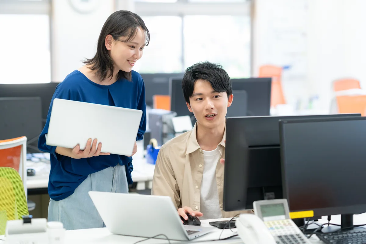 オフィスで相談しながら仕事を進めるメンバー